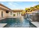 Backyard pool featuring waterfall, stairs to upper patio, and lush landscaping at 540 Regents Gate Dr, Henderson, NV 89012
