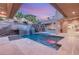 Modern backyard with pool, spa, waterfall feature, and outdoor kitchen at 540 Regents Gate Dr, Henderson, NV 89012