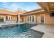 Backyard pool featuring waterfall, stairs to upper patio, outdoor kitchen, and lush landscaping at 540 Regents Gate Dr, Henderson, NV 89012