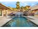 Backyard pool featuring waterfall, stairs to upper patio, and lush landscaping at 540 Regents Gate Dr, Henderson, NV 89012