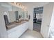 Bright bathroom featuring double sinks, modern fixtures and tile floor, with an open door to the bedroom at 5675 E La Campana Dr, Pahrump, NV 89061