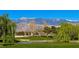 Scenic view of a lush golf course with a pond, mature trees, and mountain backdrop at 5675 E La Campana Dr, Pahrump, NV 89061