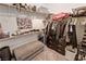 Organized walk-in closet with ample shelving and hanging space and a comfy ottoman at 5675 E La Campana Dr, Pahrump, NV 89061