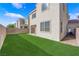 A view of the backyard showing the artificial lawn and adjacent houses at 5832 Sleepy Willow St, Las Vegas, NV 89148