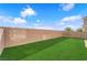 This backyard is fully enclosed with a block wall and features a green artificial lawn at 5832 Sleepy Willow St, Las Vegas, NV 89148