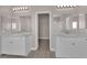 Dual sinks with large mirrors are separated by the doorway in the main bathroom at 5832 Sleepy Willow St, Las Vegas, NV 89148