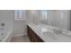 Bathroom featuring double sinks, hard surface counters, tub, and plantation shutters at 5977 Ancient Peaks Ave, Las Vegas, NV 89141