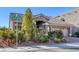 Beautiful single-story home featuring a tile roof, stone accents, mature landscaping, and an attached two-car garage at 5977 Ancient Peaks Ave, Las Vegas, NV 89141