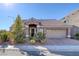 Charming single-story home with stone accents, tile roof, manicured landscaping, and a two-car garage at 5977 Ancient Peaks Ave, Las Vegas, NV 89141