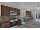 Open kitchen featuring granite counters, stainless steel appliances, and brown cabinetry at 5977 Ancient Peaks Ave, Las Vegas, NV 89141