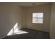 Cozy bedroom with neutral carpet, paint, and natural light streaming through window at 6020 Genovese Ave, Las Vegas, NV 89141