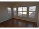 Bedroom with neutral walls, wood-look flooring, and multiple windows at 6020 Genovese Ave, Las Vegas, NV 89141