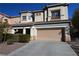 Two-story home featuring a two-car garage, desert landscaping, and a terracotta tiled roof at 6020 Genovese Ave, Las Vegas, NV 89141