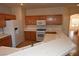 Well-lit kitchen with white appliances, wood cabinets, and a breakfast bar with sink at 6020 Genovese Ave, Las Vegas, NV 89141