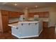 Well-lit kitchen features wooden cabinets, white appliances, and peninsula with tiled countertop at 6020 Genovese Ave, Las Vegas, NV 89141