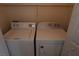 Laundry closet features a white washer and dryer with wire shelving for storage at 6020 Genovese Ave, Las Vegas, NV 89141