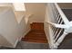 Staircase with wood steps and white railing descends from upper level with neutral carpet at 6020 Genovese Ave, Las Vegas, NV 89141