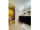 Well-lit bathroom with double vanity, dark wood cabinets, large mirror, and tile floors at 6495 Little Harbor Ct, Las Vegas, NV 89141