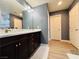 Well-lit bathroom featuring a large mirror above a dark vanity with a white marble countertop and wood flooring at 6495 Little Harbor Ct, Las Vegas, NV 89141
