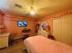 Bright pink bedroom featuring a ceiling fan, TV, closet, dresser, and laminate flooring at 6495 Little Harbor Ct, Las Vegas, NV 89141