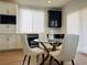 Bright dining area with a modern glass table and stylish white chairs, enhancing the home's appeal at 6495 Little Harbor Ct, Las Vegas, NV 89141