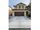 Two-story home featuring a spacious two-car garage, neutral stucco, and decorative shutters over the windows at 6495 Little Harbor Ct, Las Vegas, NV 89141