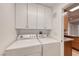 Functional laundry room with washer, dryer, and white cabinets for storing detergent at 701 Capri Dr # 16B, Boulder City, NV 89005