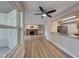 Bright living room with a fireplace, wood floors, ceiling fan, and opening that looks into the kitchen at 701 Capri Dr # 16B, Boulder City, NV 89005