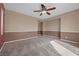A bright, carpeted bedroom featuring a ceiling fan, neutral walls, and ample natural light at 8216 Swallow Falls St, North Las Vegas, NV 89085
