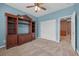 Carpeted bedroom with ceiling fan, built-in shelving unit, and closet at 8216 Swallow Falls St, North Las Vegas, NV 89085