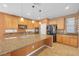 Spacious kitchen featuring wooden cabinetry, granite counters, and a large central island at 8216 Swallow Falls St, North Las Vegas, NV 89085
