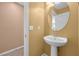 Cozy powder room featuring a pedestal sink, decorative mirror, and neutral wall colors at 8216 Swallow Falls St, North Las Vegas, NV 89085