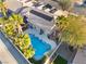 Serene aerial view featuring a private pool surrounded by palm trees, a covered patio, and beautifully landscaped yard at 8354 Woodland Prairie Ave, Las Vegas, NV 89129