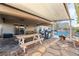 Covered patio area with dining furniture and BBQ grill, near the pool at 8354 Woodland Prairie Ave, Las Vegas, NV 89129