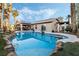 Backyard pool area with covered patio, rock features and green landscaping at 8354 Woodland Prairie Ave, Las Vegas, NV 89129