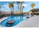 Backyard pool with palm trees and a nearby covered patio at 8354 Woodland Prairie Ave, Las Vegas, NV 89129