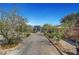 Backyard showcasing a detached garage, accented by mature trees and a path to a garden area in this tranquil outdoor setting at 8365 Haven St, Las Vegas, NV 89123
