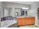 Bathroom featuring double sinks, large tub, and marble countertops at 8365 Haven St, Las Vegas, NV 89123