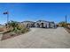 Home exterior with a circle driveway, porte-cochere, and desert landscaping at 8365 Haven St, Las Vegas, NV 89123