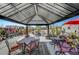 Under a metal gazebo, a backyard shows an outdoor dining and seating area with potted plants under the shade at 8365 Haven St, Las Vegas, NV 89123