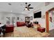 Inviting living room with a ceiling fan, red leather seating, display case, and large windows for natural light at 8365 Haven St, Las Vegas, NV 89123