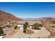 Aerial view of property featuring desert landscaping, mountain views, lake, and mature trees at 879 Judi Pl, Boulder City, NV 89005