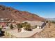 Home situated on a hill with beautiful mature trees, a circle drive, and desert landscaping at 879 Judi Pl, Boulder City, NV 89005