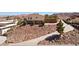 Hillside home with rock landscaping and a curved driveway leading to street at 879 Judi Pl, Boulder City, NV 89005