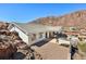 Exterior view of home with a covered patio, desert landscaping and mountain views at 879 Judi Pl, Boulder City, NV 89005