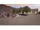 Exterior view of home with desert landscaping and mature shade trees with long driveway, and mountain views at 879 Judi Pl, Boulder City, NV 89005