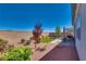 Well-manicured backyard with lush landscaping, patio area, and desert plants at 8944 Skye Canyon Ranch St, Las Vegas, NV 89166