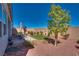 Landscaped backyard with patio, artificial turf, and desert-friendly plants at 8944 Skye Canyon Ranch St, Las Vegas, NV 89166