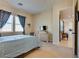 Comfortable bedroom featuring neutral colors, plush carpet, and two windows with blue curtains at 8944 Skye Canyon Ranch St, Las Vegas, NV 89166