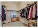 Walk-in closet with wooden chest and hanging clothes at 8944 Skye Canyon Ranch St, Las Vegas, NV 89166